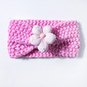 Detailed view of pink knitted baby headband featuring a soft 3D floral decoration