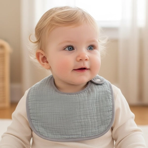 Gros plan d'un bavoir pour bébé en coton gris avec détail de fermeture à pression