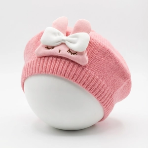 Pink knit baby beret with a large white bow, bunny ears, and cute embroidered details