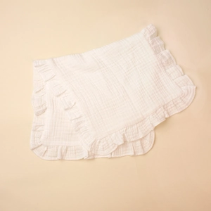Macro shot of layered soft cotton muslin baby burp cloth with delicate ruffle edges