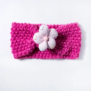 Detailed knit texture and floral fabric embellishment on baby headband in rose red