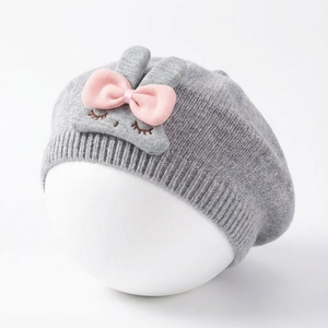 Detail of grey baby bunny beret featuring cute knitted pink ears and decorative bow