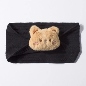 Détail d'un bandeau bébé en maille côtelée noire avec un petit ours en peluche marron