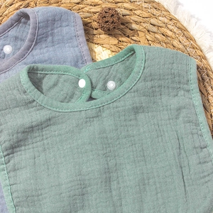 Détail de bavoirs en mousseline de coton pour bébé avec boutons et texture de gaze douce