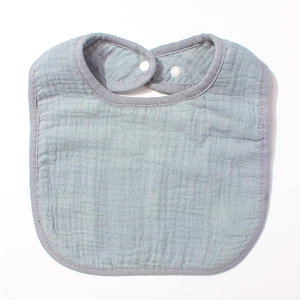 Détail du bavoir en mousseline de coton pour bébé avec bouton pression en bleu clair