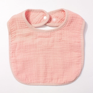 Vue détaillée du bavoir en gaze de coton rose pour bébé avec fermeture à pression