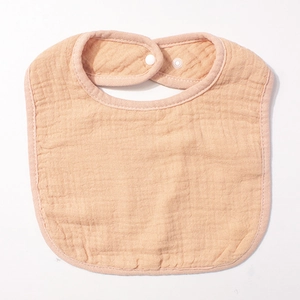 Détail de la texture en gaze de coton multicouche et du bouton-pression du bavoir