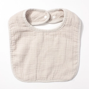 Vue détaillée du bavoir en gaze de coton avec texture douce et boutons-pression blancs