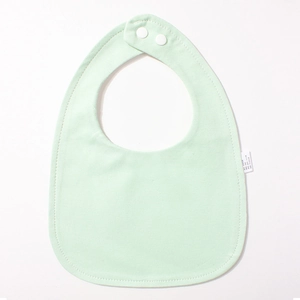 Detailaufnahme von mintgrünem Baby-Lätzchen mit Baumwolltextur, Druckknöpfen und Etikett
