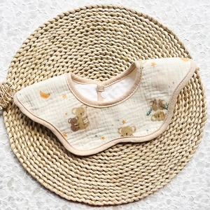 Close-up of baby bib with koala print on gauze fabric and snap button detail