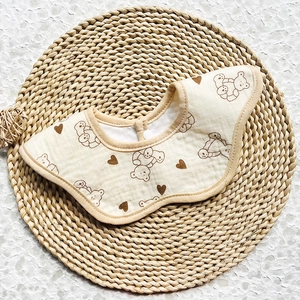 Detail view of cotton muslin baby bib with cute bear prints and secure snap button