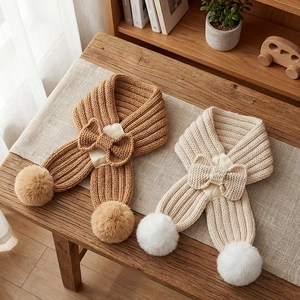 Knitted kids bow scarf with soft pompoms in caramel and beige for autumn and winter