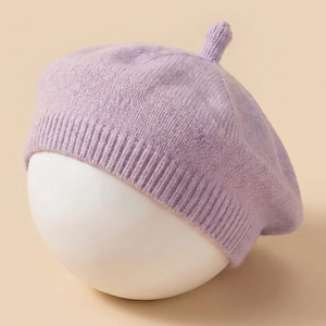 Solid purple knitted baby beret hat with ribbed edge on a white display stand