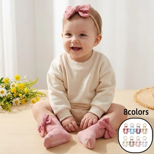 Detail of baby anti-slip socks with bow and matching headband in soft pink cotton