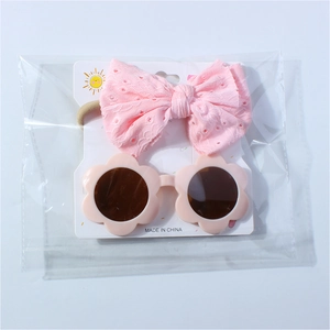 Bandeau à nœud en dentelle rose et lunettes fleurs pour bébé sur carte emballage