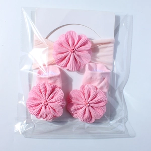 Detailansicht von Baby-Stirnband und Socken-Set in Rosa mit großen 3D-Blumen