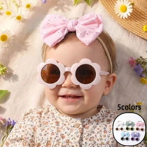 Détail de lunettes de soleil fleurs roses et bandeau brodé à nœud pour bébés filles