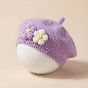 Close-up of a purple knitted baby beret featuring 3D floral details and soft texture