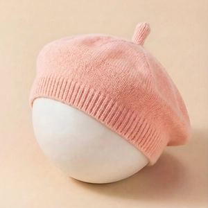 Detailed knit texture of pink baby beret with ribbed rim and cute pointed top