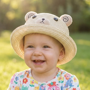 Photo en plein air d'un chapeau de paille pour bébé avec oreilles d'ours peluche