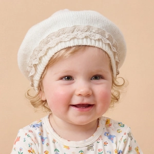 Gros plan du béret en maille pour bébé avec bordure en dentelle et bord côtelé