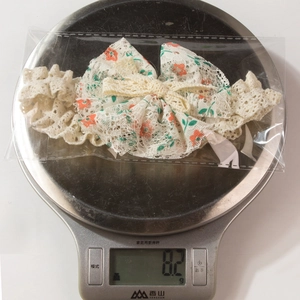 Detailansicht weißes Baby-Stirnband aus Spitze mit orangefarbenen Blumen, Gewicht 8,2g