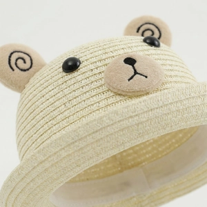 Gros plan d'un chapeau de paille pour bébé avec oreilles d'ours 3D et texture tissée