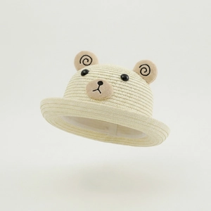Détail d'un chapeau de paille pour bébé avec oreilles d'ours et broderie de visage