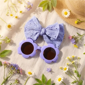 Détail de lunettes de soleil fleur bébé violettes et bandeau à nœud brodé assorti