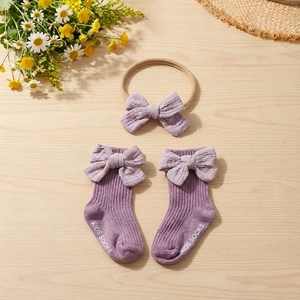 Detailed close-up of lilac cotton baby headband and non-slip socks with bow set