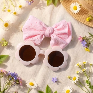 Bandeau à nœud en dentelle rose et lunettes de soleil fleur bébé sur fond lin