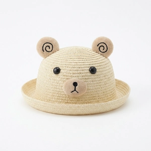 Détail d'un chapeau de paille pour bébé avec oreilles d'ours et texture tissée d'été