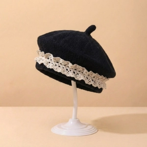 Détail du béret tricoté pour bébé avec texture laine noire et bordure dentelle blanche