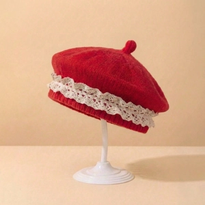 Détail du béret en tricot rouge pour bébé avec bordure en dentelle blanche délicate