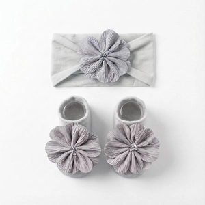 Detailansicht von Baby-Stirnband und passenden Socken mit Blumen in hellem Hellgrau