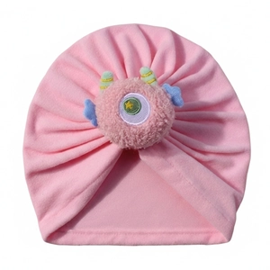 Dettaglio ravvicinato del berretto rosa per neonati in pile con mostro 3D decorativo