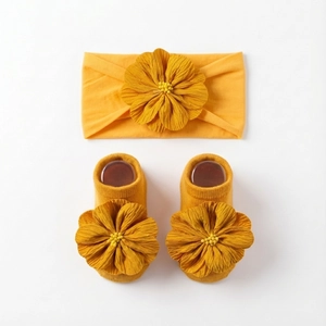 Makro-Detail von Baby-Stirnband und Socken Set in Ingwergelb mit 3D-Blumendekor