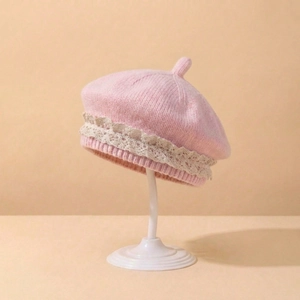 Détail d'un béret tricoté rose pour bébé avec bordure en dentelle beige et texture douce