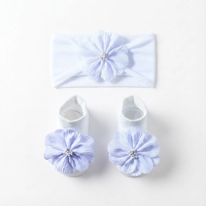 Details von weißem Baby-Stirnband und Socken mit zarten lavendelfarbenen Stoffblumen
