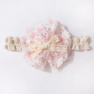 Detailansicht eines Baby-Spitzenstirnbandes mit rosa Blumenmuster und kleiner Schleife