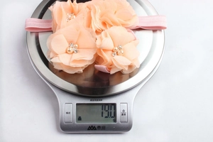 Detail of four handmade chiffon flower headbands with pearls and rhinestones for infants