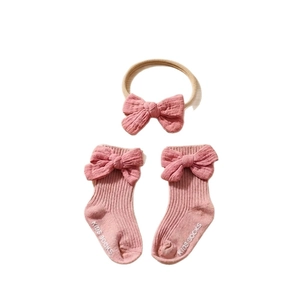 Pink cotton baby bow headband and ribbed non-slip socks set for infants and toddlers