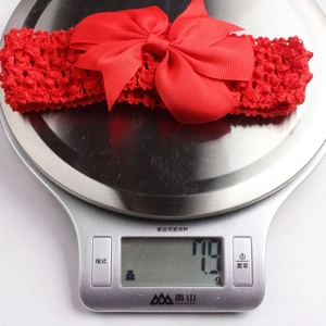 Lightweight red bow baby headband on scale showing exact product weight of 7.9g