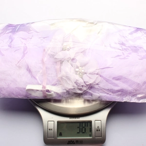 Mesure du poids des ailes d'ange en plumes mauves avec détails de fleurs et perles