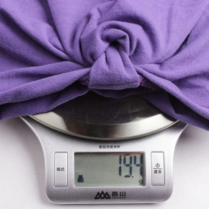 Détail du turban bébé en polaire violette affichant un poids de 194g sur une balance