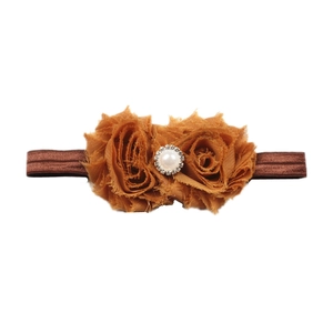 Détail du bandeau bébé avec deux fleurs en mousseline caramel, perles et cristaux