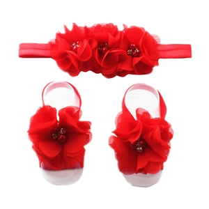 Detail view of baby chiffon floral headband and barefoot sandals set in bright red