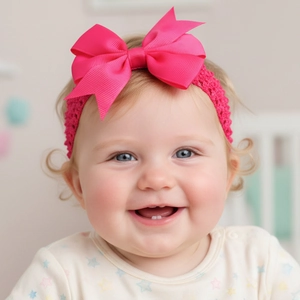 Detail of rose pink oversized ribbed bow headband with crochet elastic band on an infant