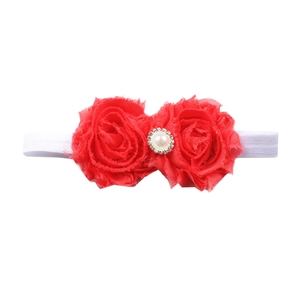 Détail d'un bandeau bébé avec roses en mousseline rouge, perle et cristaux brillants