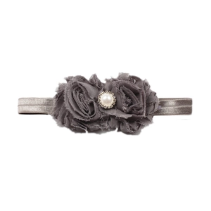 Détail de fleurs en mousseline grise avec perles et strass sur un bandeau élastique bébé